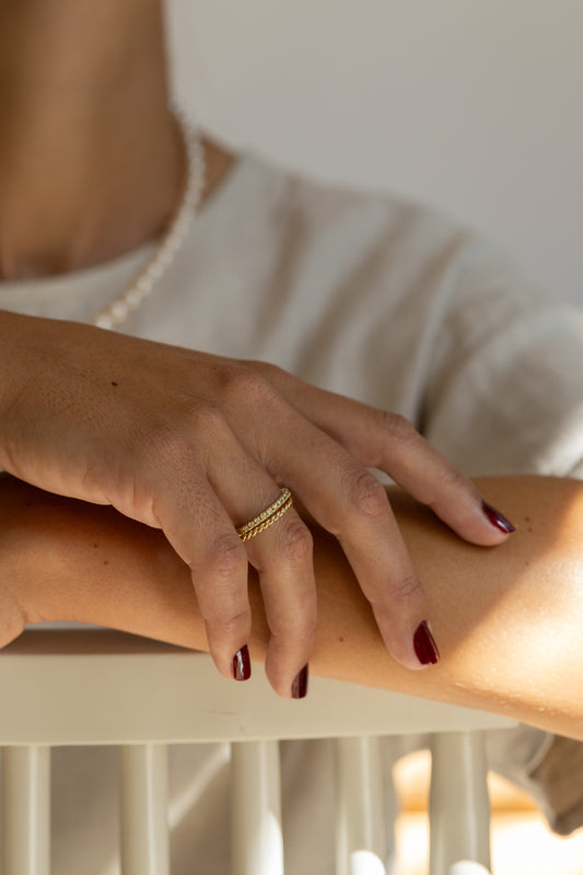 Close-up of a hand with a gold ring on a blurred background