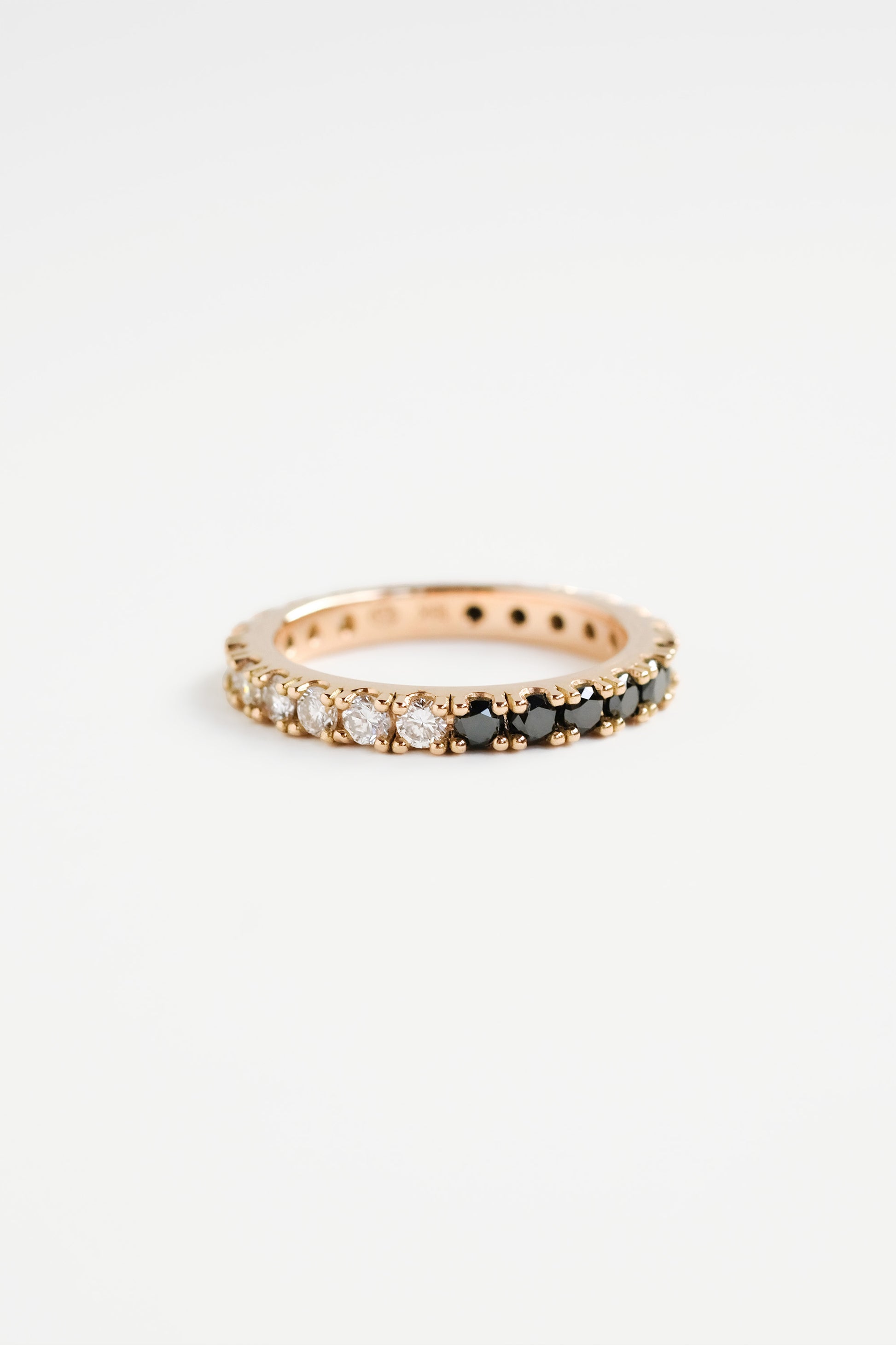 A full eternity ring with a half-and-half design of black and white diamonds, displayed on a plain background.