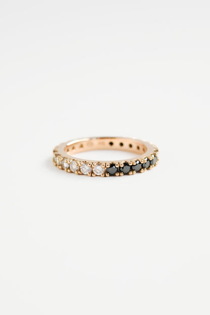 A full eternity ring with a half-and-half design of black and white diamonds, displayed on a plain background.