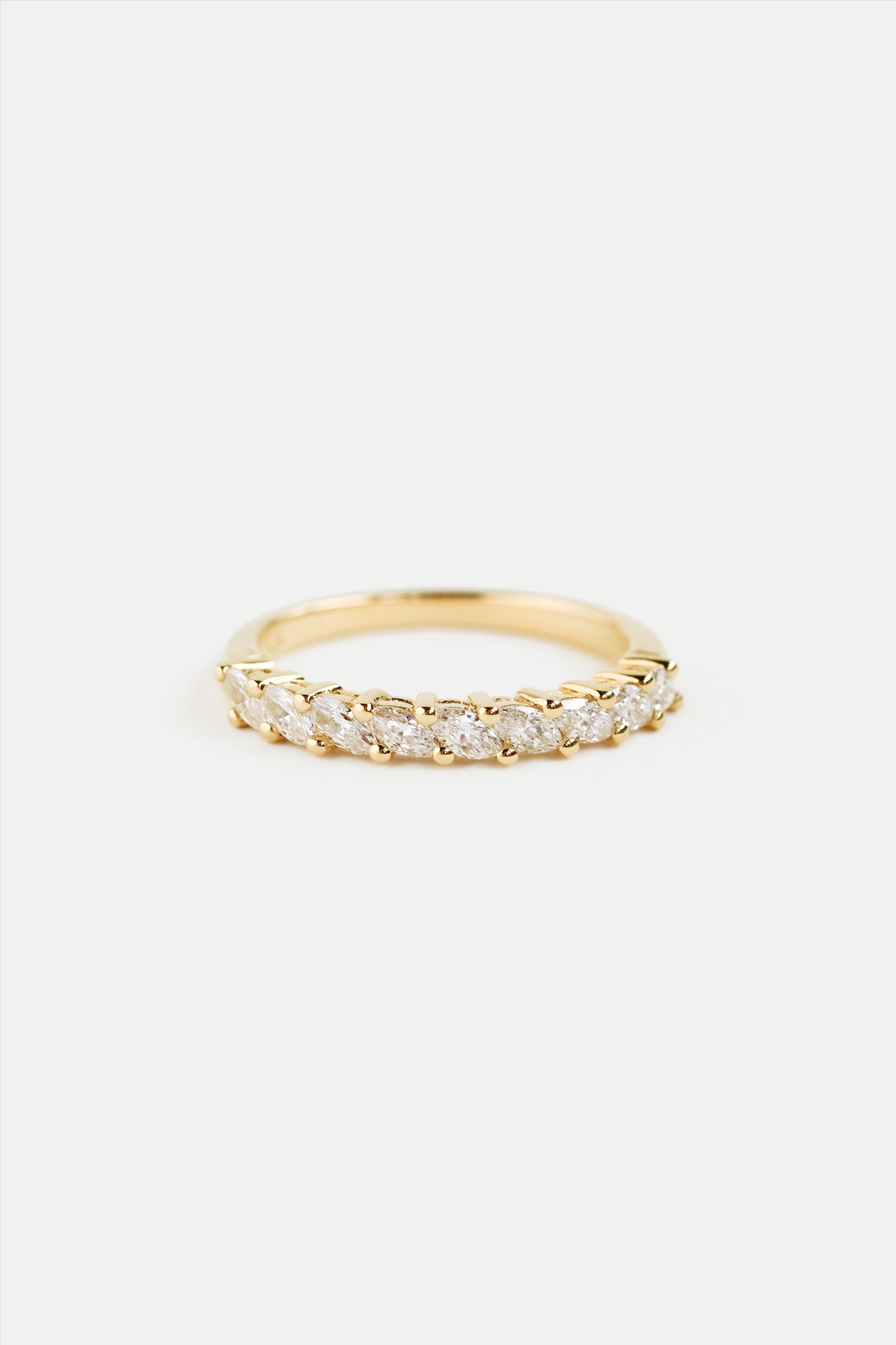 A gold half eternity ring with marquise diamonds set around the band.