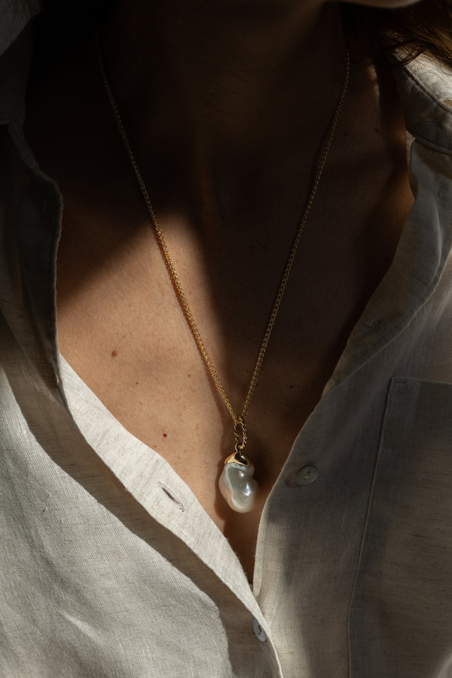 Necklace with a pendant worn by a person, close-up on the neck