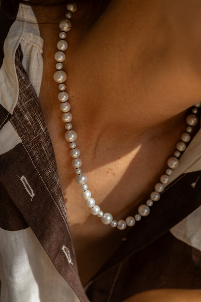 Close-up of a pearl necklace with pattern shirt